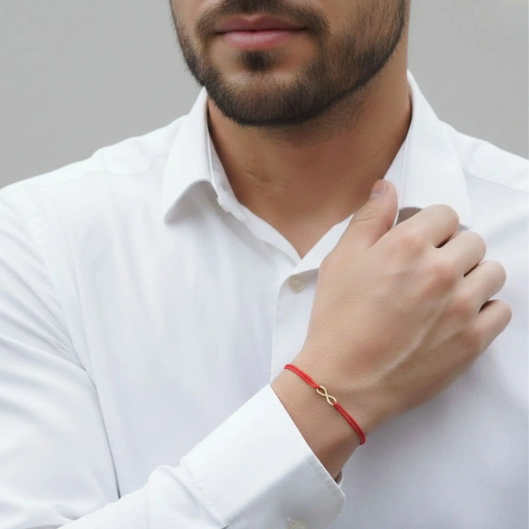 Man wearing a white shirt with a red bracelet on his wrist.