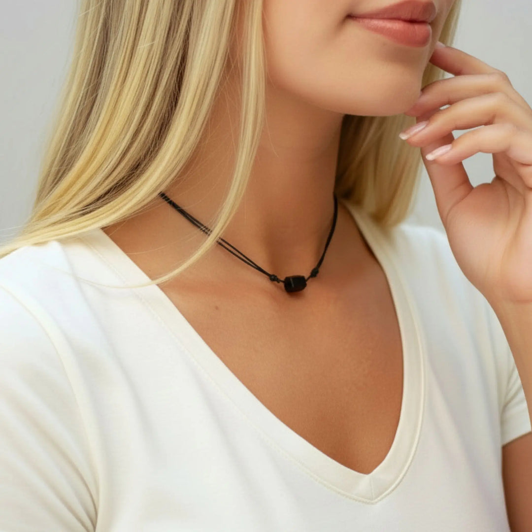 Woman wearing a black tourmaline necklace with a plain background