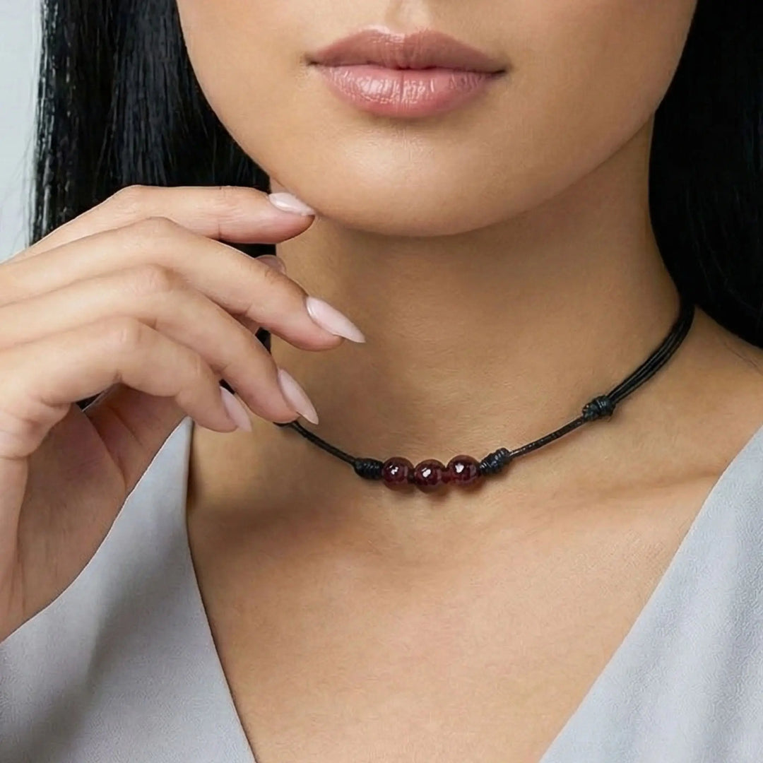 Close-up of a woman wearing a necklace with red beads.