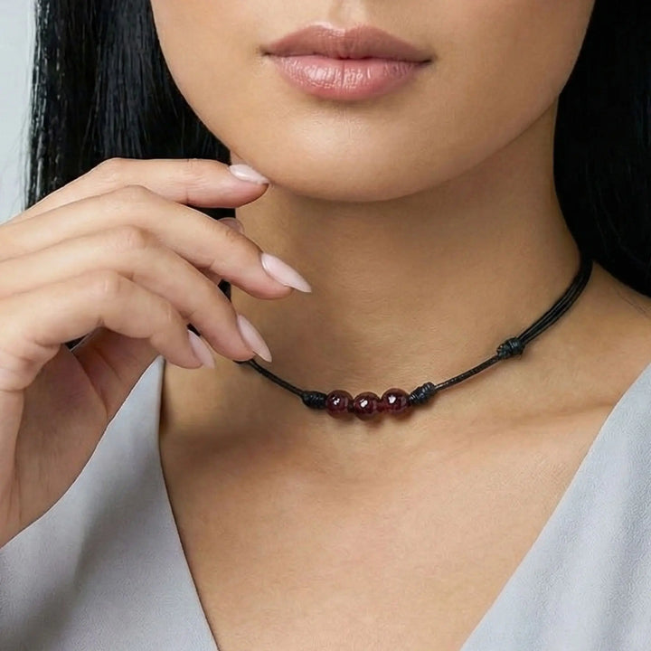 Close-up of a woman wearing a necklace with red beads.