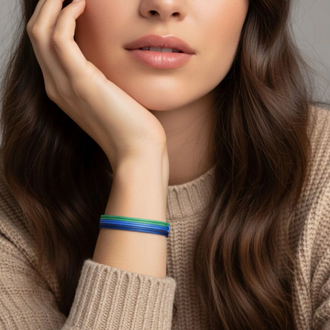 Woman wearing a colorful bracelet on her wrist with a neutral background