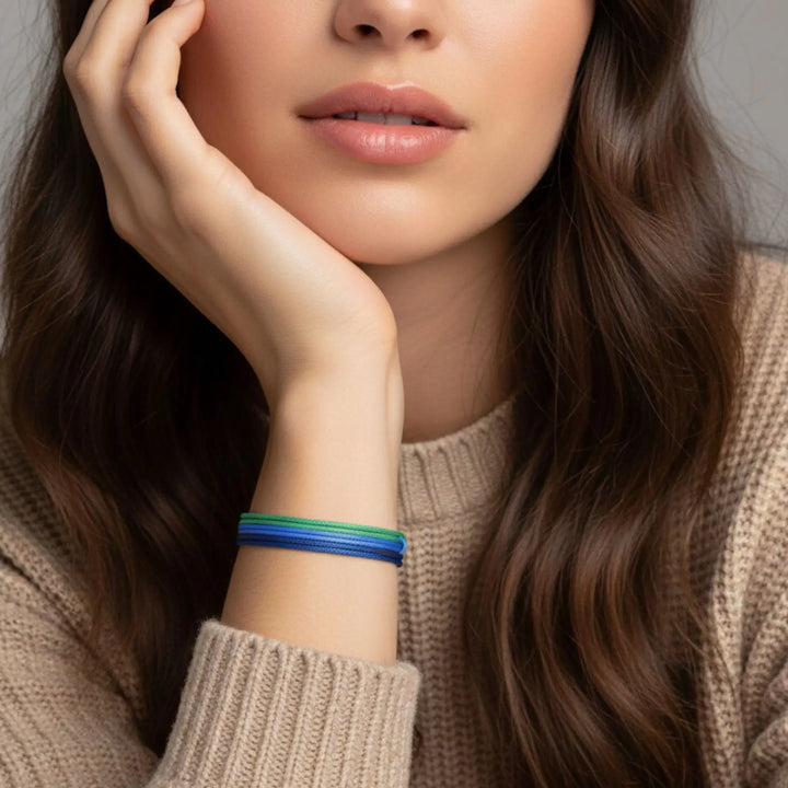 Woman wearing a colorful bracelet on her wrist with a neutral background