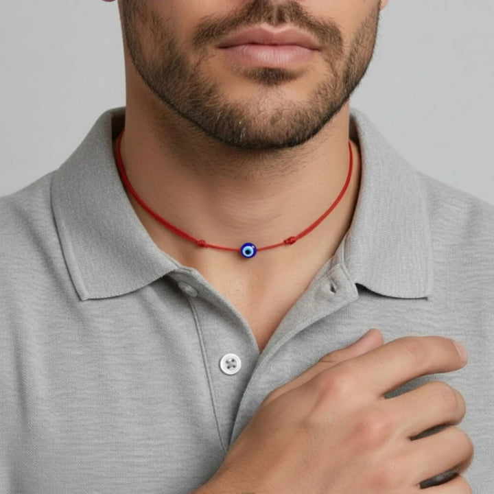 Man wearing a red necklace with a blue eye pendant on a gray background