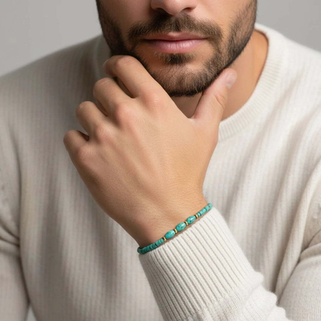 Man wearing a turquoise bracelet on a neutral background