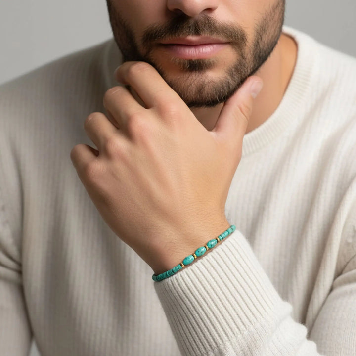 Man wearing a turquoise bracelet on a neutral background