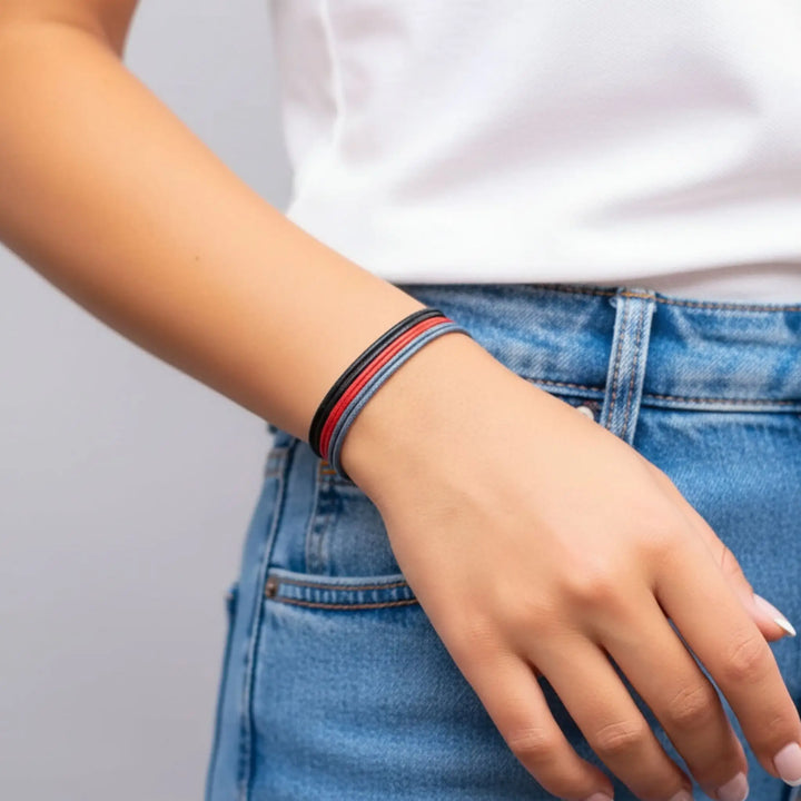 Person wearing a colorful bracelet on a plain background