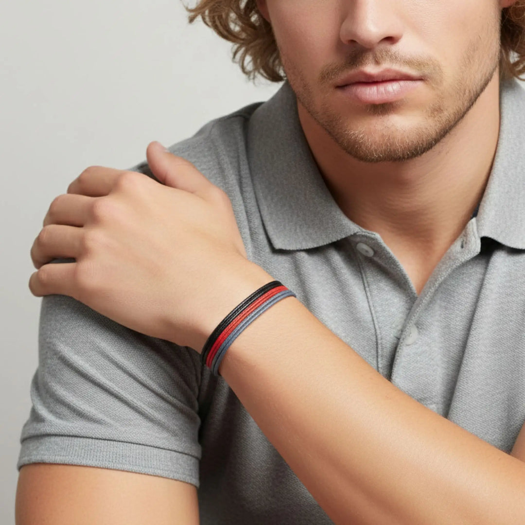 Man wearing a gray polo shirt with a close-up of his arm showing a bracelet.