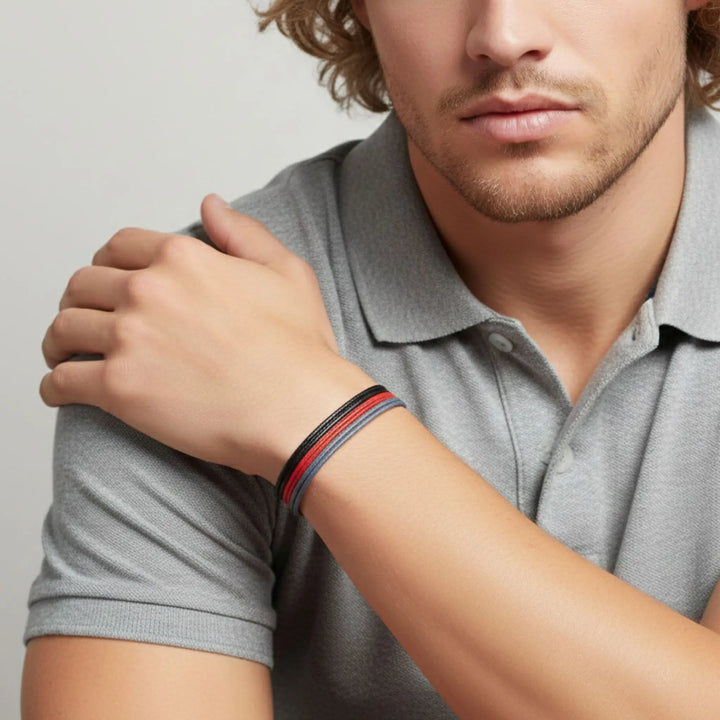 Man wearing a gray polo shirt with a close-up of his arm showing a bracelet.