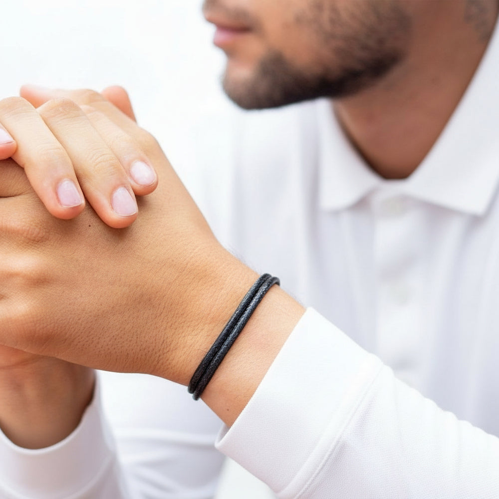 thick black cord bracelet on a man with white shirt