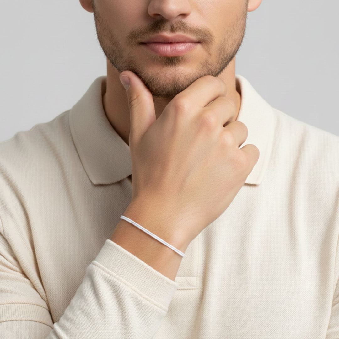 Man wearing adjustable white cord bracelet on his wrist.
