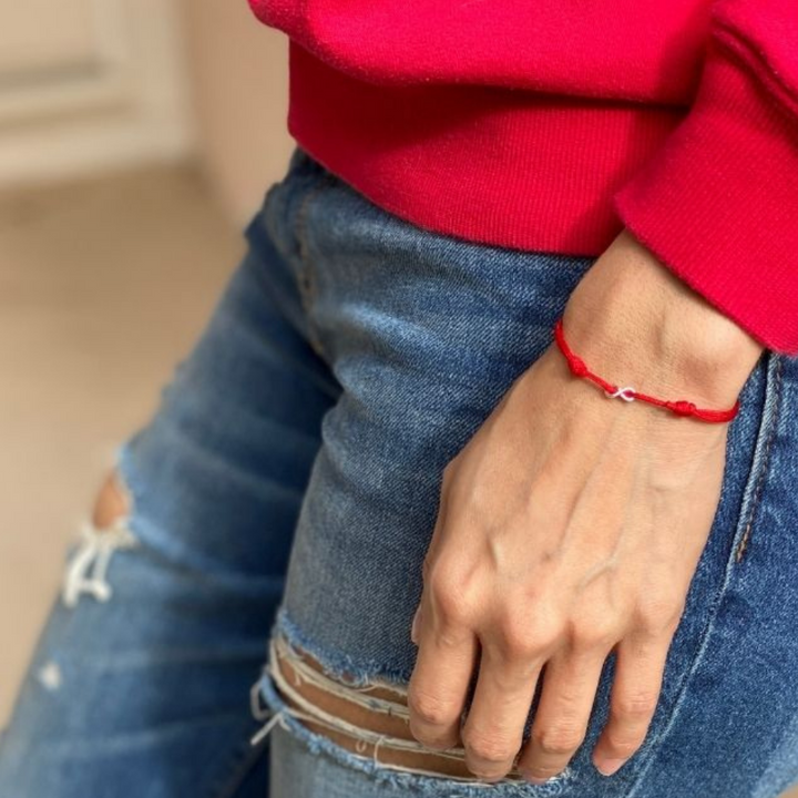 Woman gracefully wearing the Sterling Silver Red String Infinity Bracelet, symbolizing eternal elegance and protection - Luck Strings