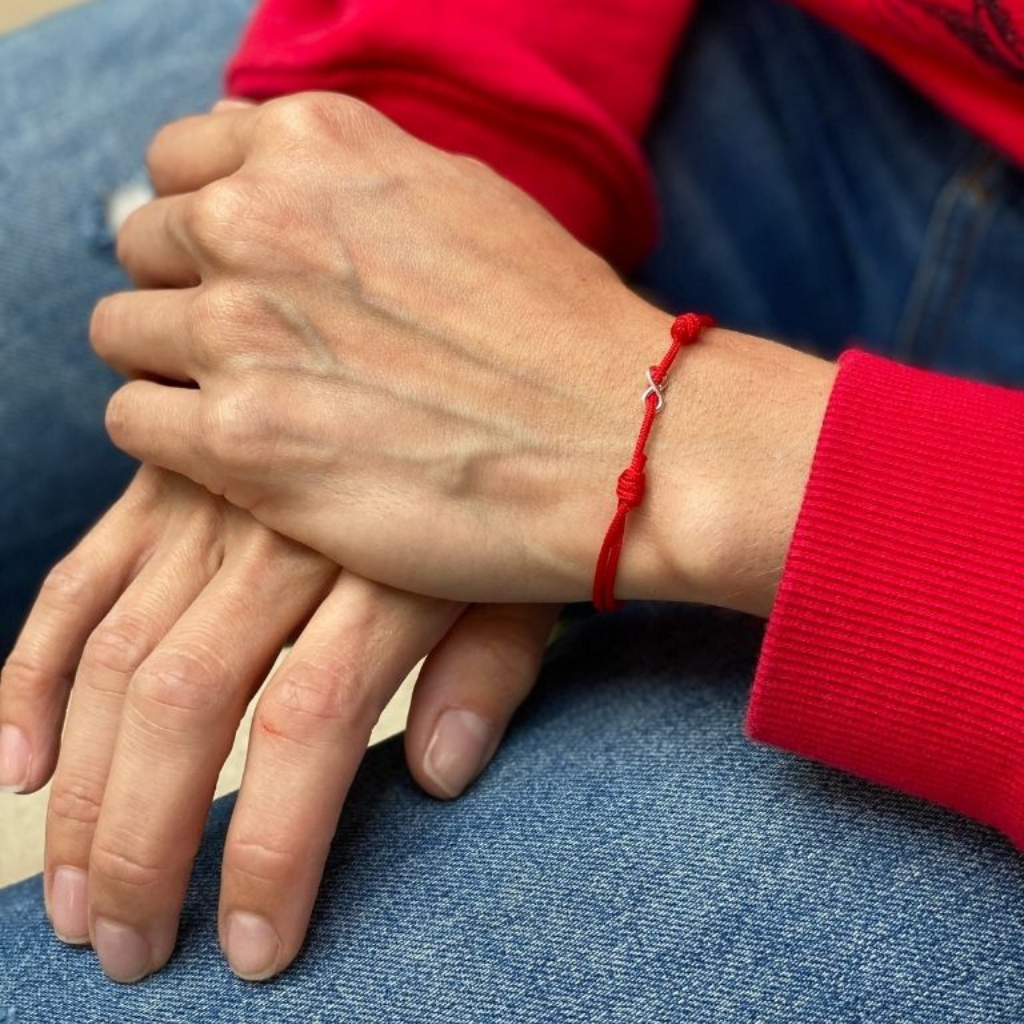 Woman gracefully wearing the Sterling Silver Red String Infinity Bracelet, symbolizing eternal elegance and protection - Luck Strings