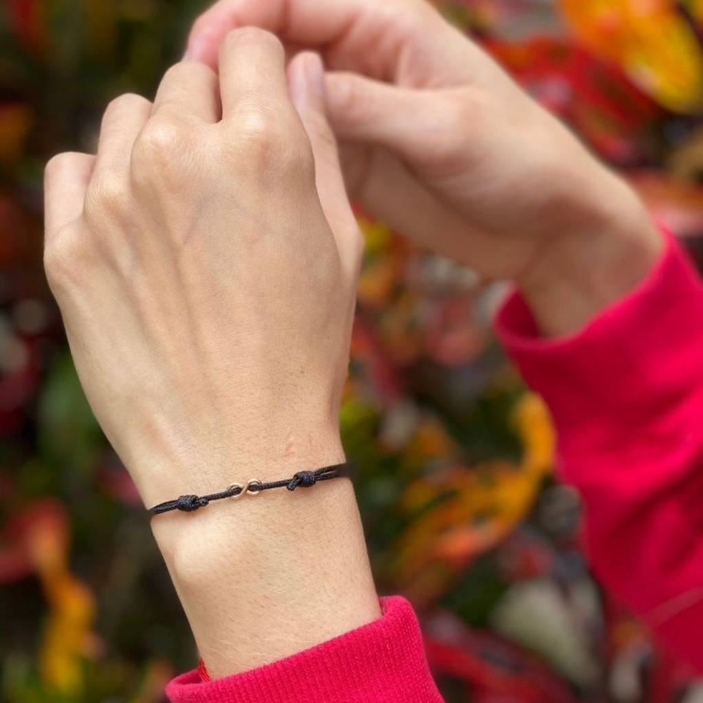 Woman gracefully wearing the Sterling Silver Red String Infinity Bracelet, symbolizing eternal elegance and protection - Luck Strings