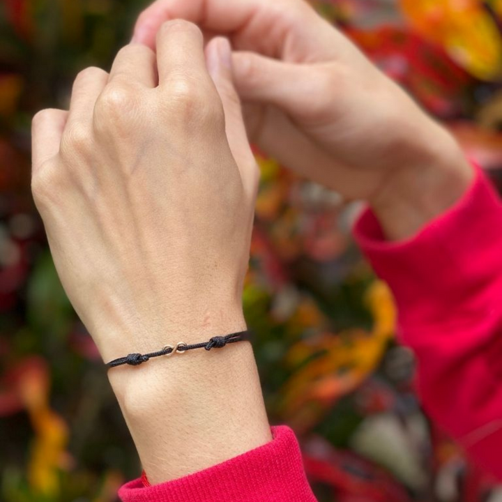 Woman gracefully wearing the Sterling Silver Red String Infinity Bracelet, symbolizing eternal elegance and protection - Luck Strings