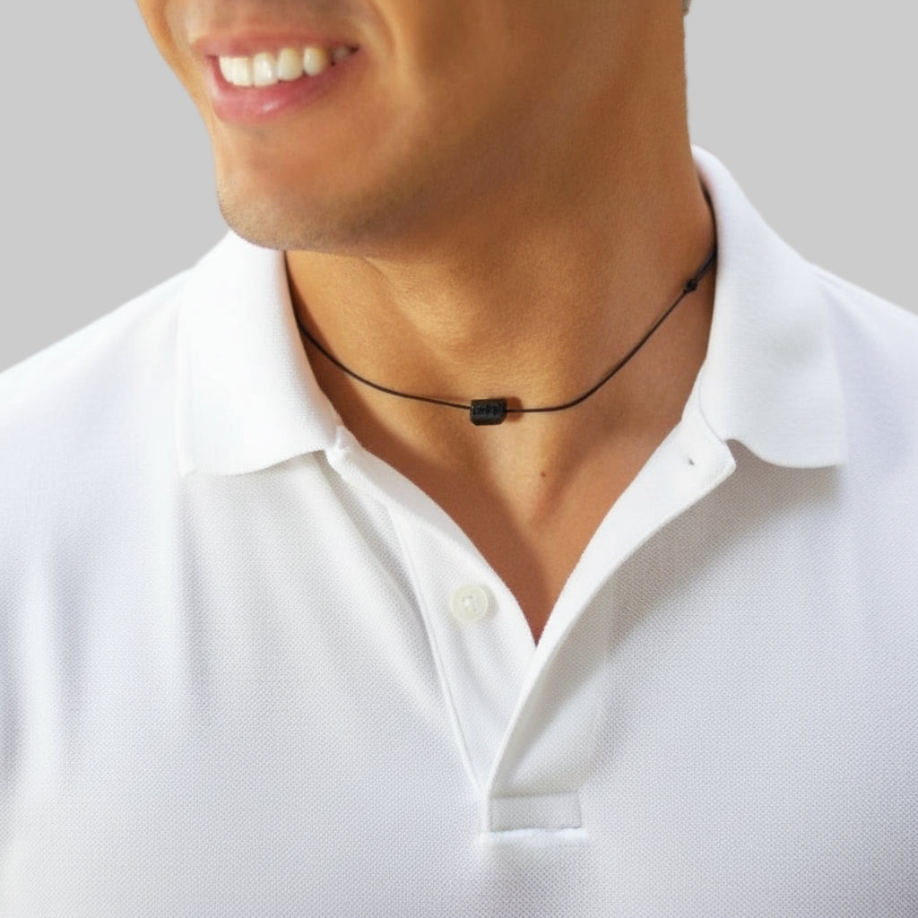 Close-up of a person wearing a black string black tourmaline necklace 